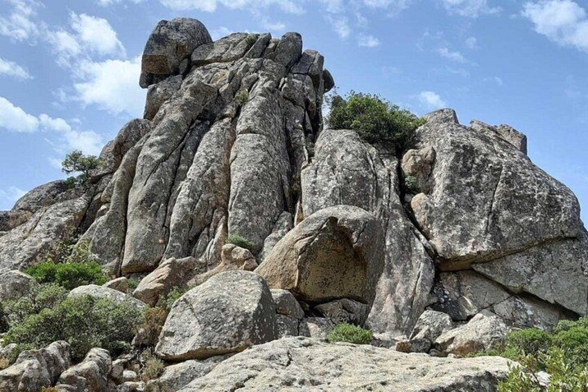 A rocky outcrop with large boulders and sparse vegetation. 2