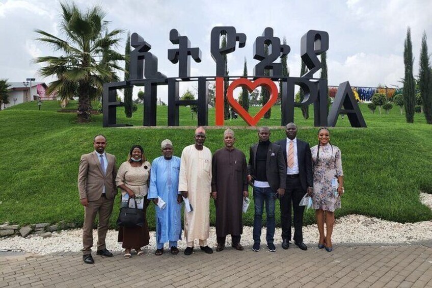 A group of people standing in front of a sign with the text "ETHIOPIA" and a heart symbol. 1