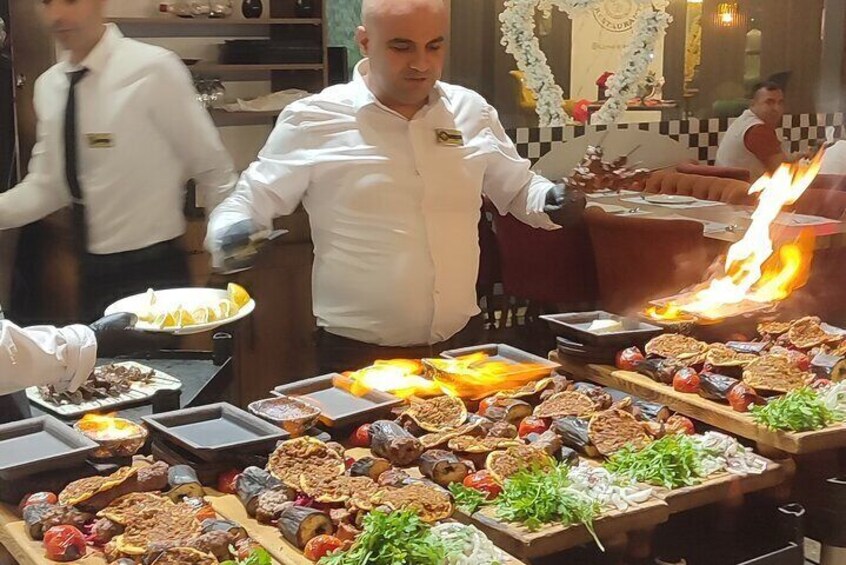 A chef preparing food in a kitchen with various dishes and ingredients on the counter. 2