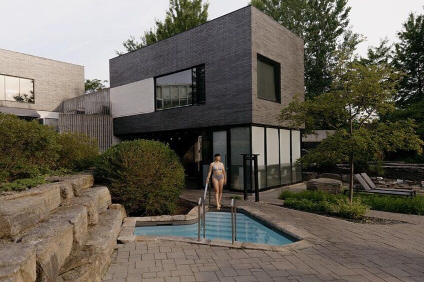 Une maison moderne avec une piscine, une personne en maillot de bain et un jardin. 4