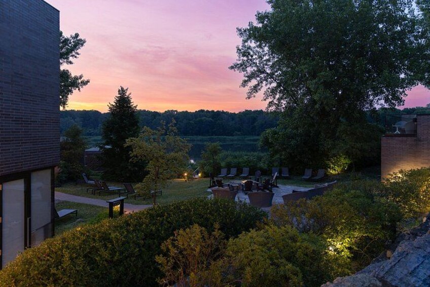 Un coucher de soleil sur une zone résidentielle, avec une terrasse, des arbres et un immeuble. 5