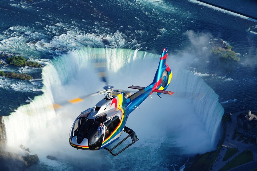 Helicopter flying over Niagara Falls offering stunning aerial views.
