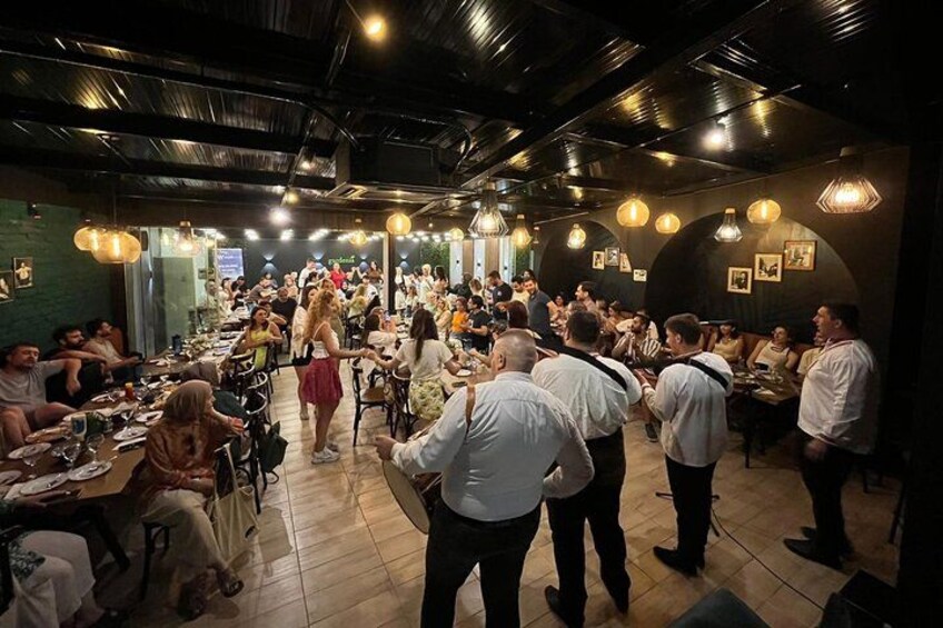 A crowded restaurant with people dining and socializing. 2