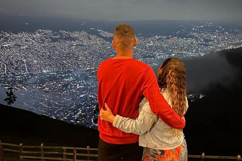 A couple embracing with a cityscape in the background. 1