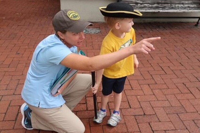 A person in a blue shirt and cap pointing at another person in a yellow shirt and hat. 4