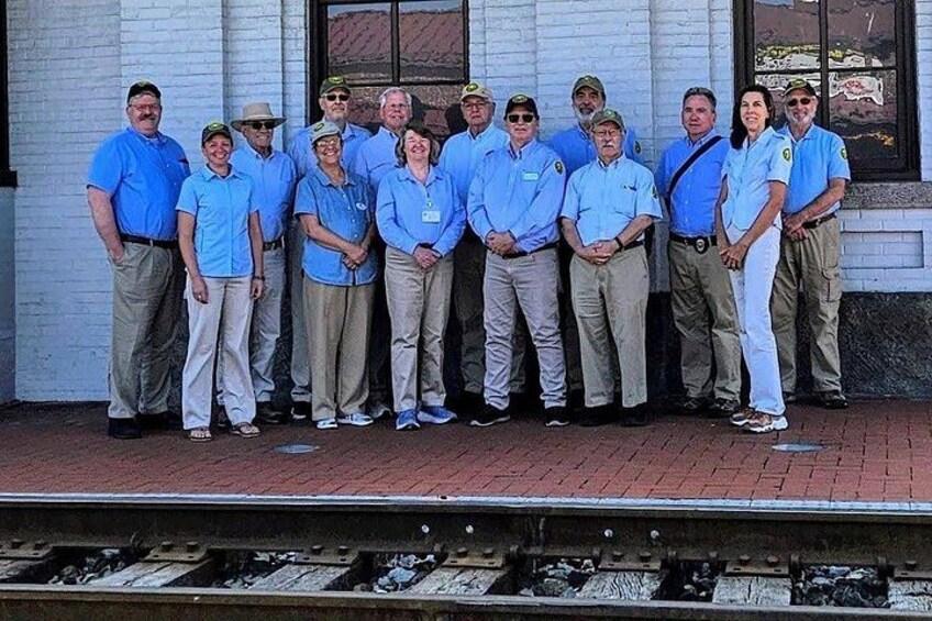 A group of people standing in front of a building with a brick facade and a window. 3
