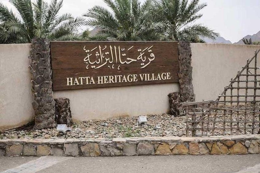 Skilt for Hatta Heritage Village med arabisk skrift og engelsk tekst. 2