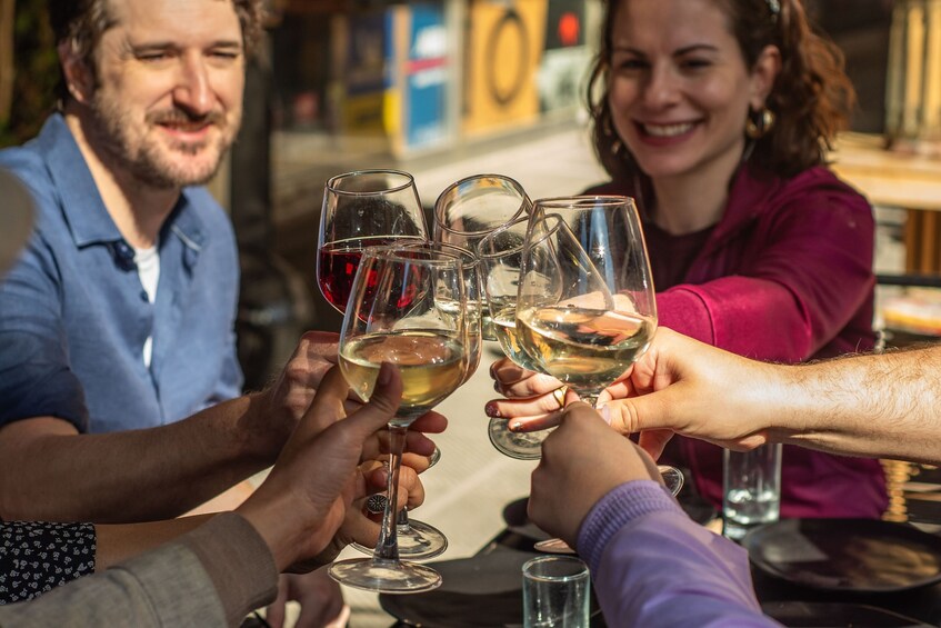A group of people toasting with wine glasses. 3