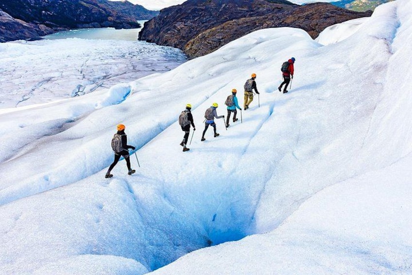 A group of hikers ascending a snow-covered mountain with a glacier in the background. 1