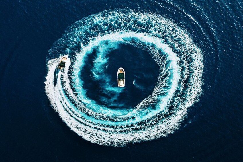 A boat creating a circular wake pattern in the ocean. 1