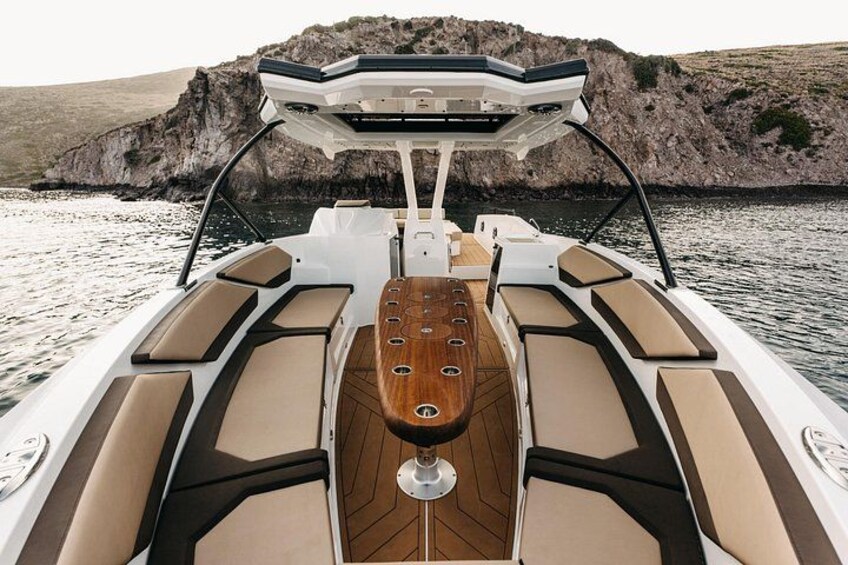 A boat with a wooden deck and cushioned seating. 3