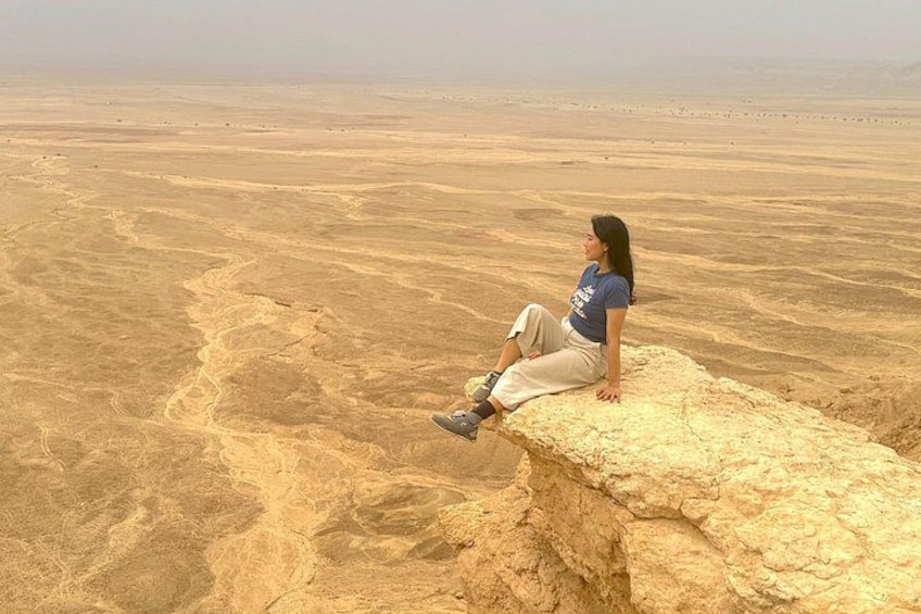 A person sitting on a rock in a desert landscape. 2