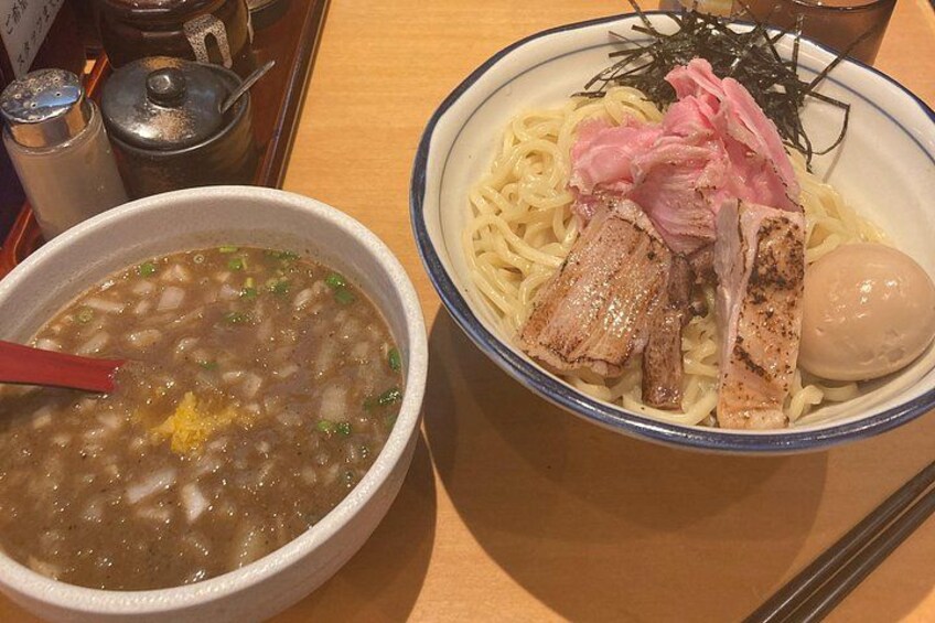 Un tazón de ramen con fideos, cerdo y un huevo cocido. 2
