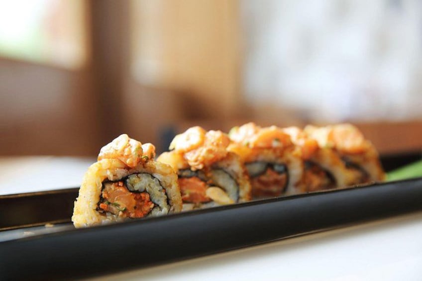 A sushi dish with a black plate. 3