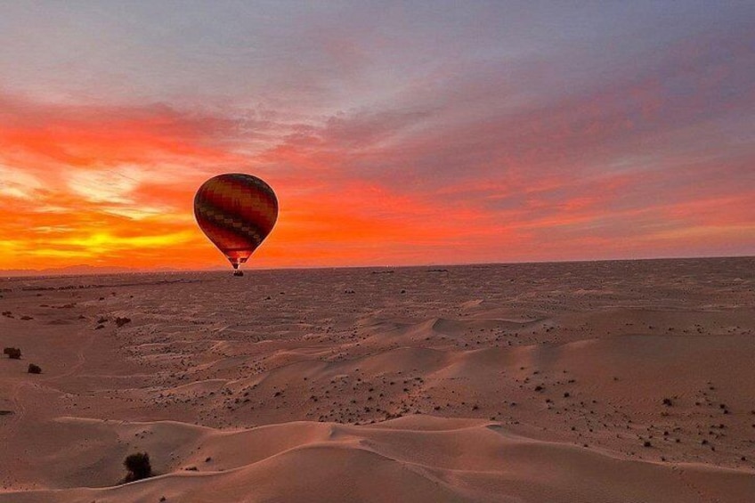 Een luchtballon boven een woestijnlandschap tijdens de zonsondergang. 4