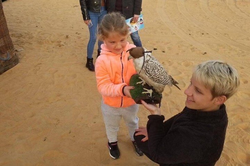 Iemand houdt een vogel vast, een ander persoon houdt een pluche knuffel vast, en een kind op de achtergrond. 3