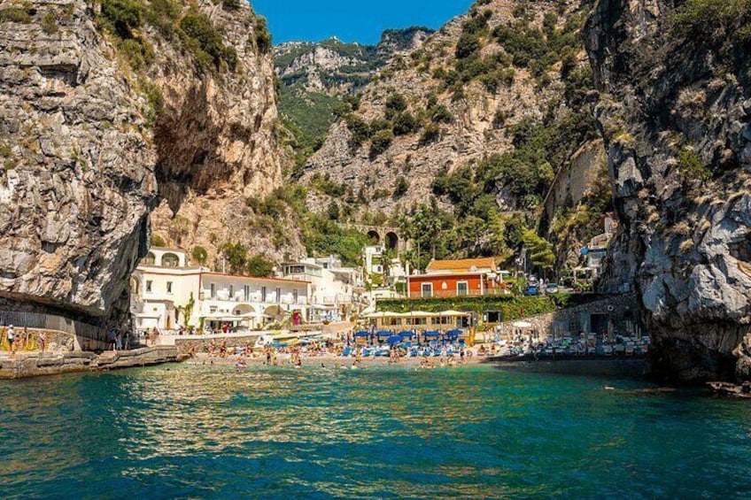 Un pueblo costero con edificios, una playa y acantilados rocosos. 2