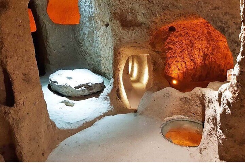 A cave interior with stalactites, a rock formation, and a small pool of water. 4