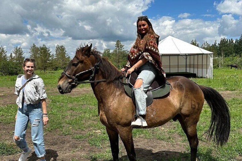 A person riding a horse in a grassy field with a tent in the background. 4