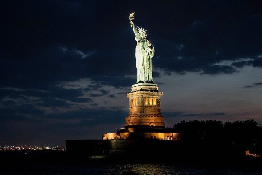 The Statue of Liberty illuminated at night. 4