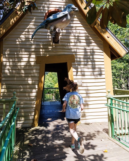 A person walking towards a building with a bird sculpture on the roof. 5