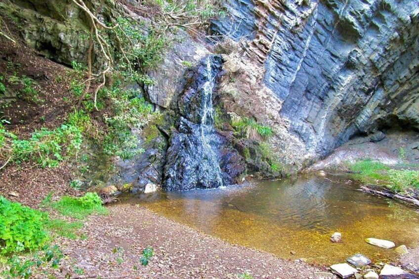 Ein Wasserfall, felsiges Gelände und ein kleiner Teich. 3