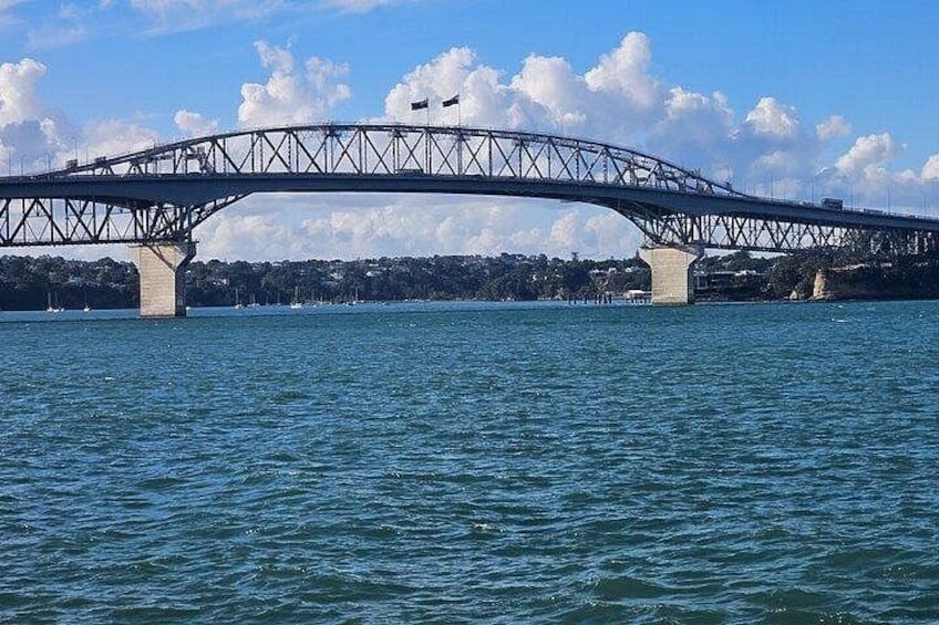 Un ampio ponte che attraversa un corso d'acqua, con cielo sereno e nuvole sullo sfondo. 3