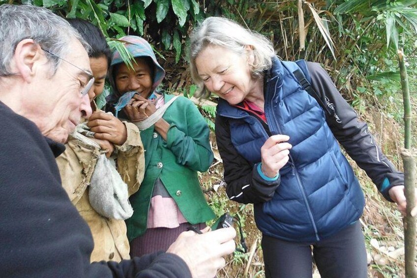 A group of people in a forested area, some wearing outdoor clothing. 2