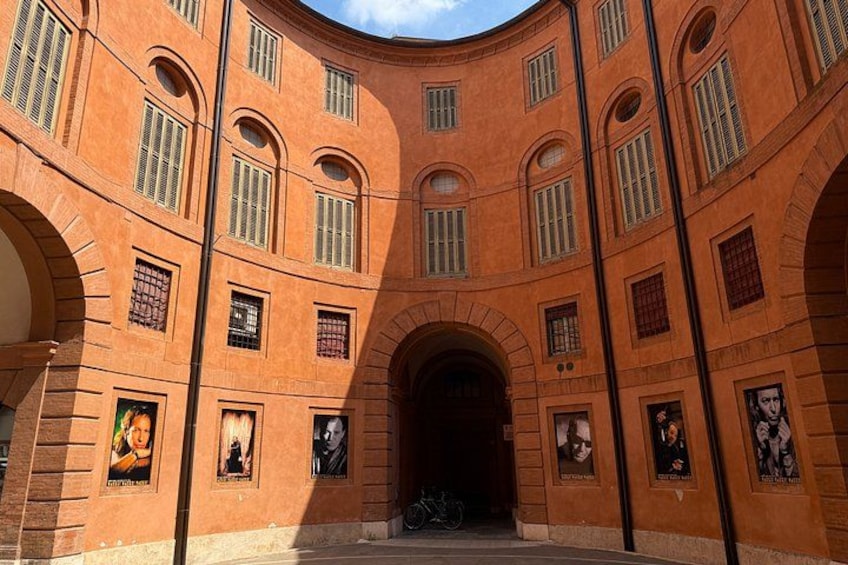 Un bâtiment en briques aux lignes courbes, doté d’entrées en arc de cercle et de nombreuses fenêtres. 2