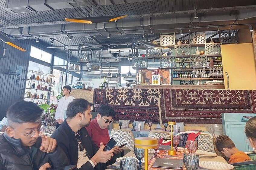 En restaurantindretning med borde, stole og en bar. 3