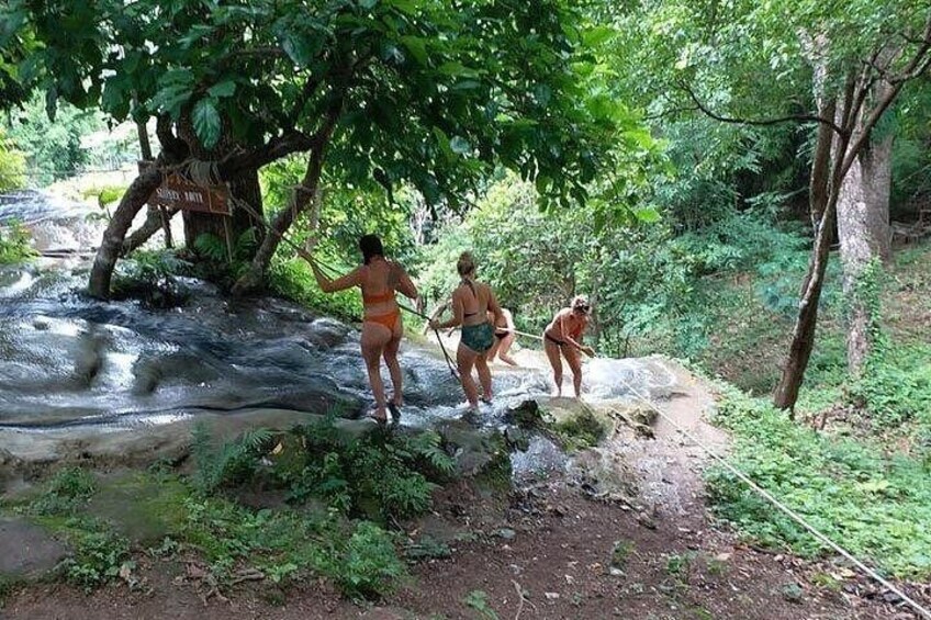 Deux personnes traversent un petit ruisseau dans une zone boisée. 2
