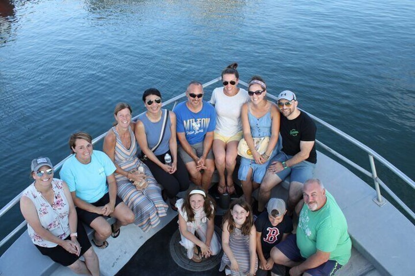 A group of people on a boat with calm water in the background. 2
