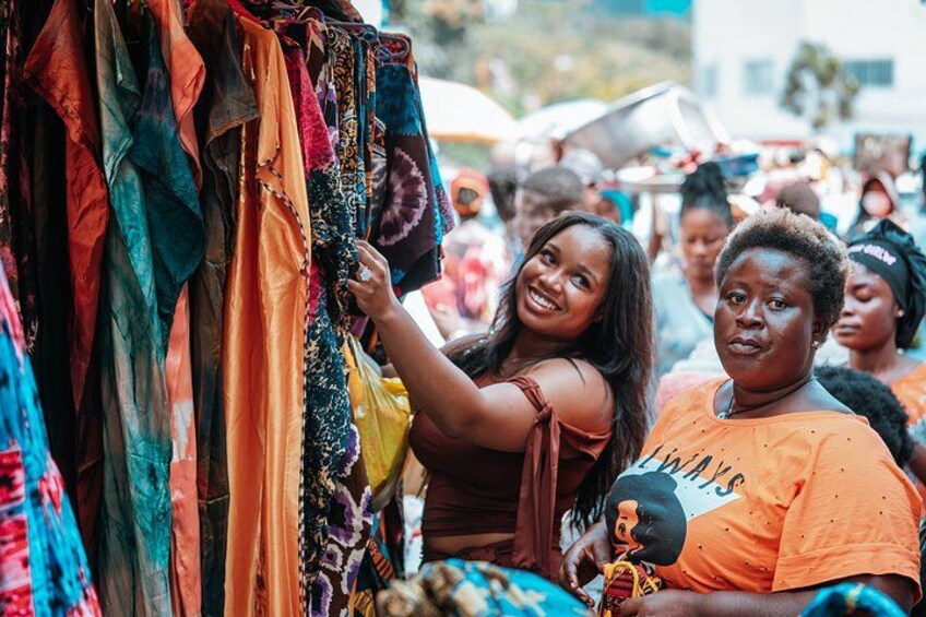 A market scene with colorful fabrics hanging for sale. 1