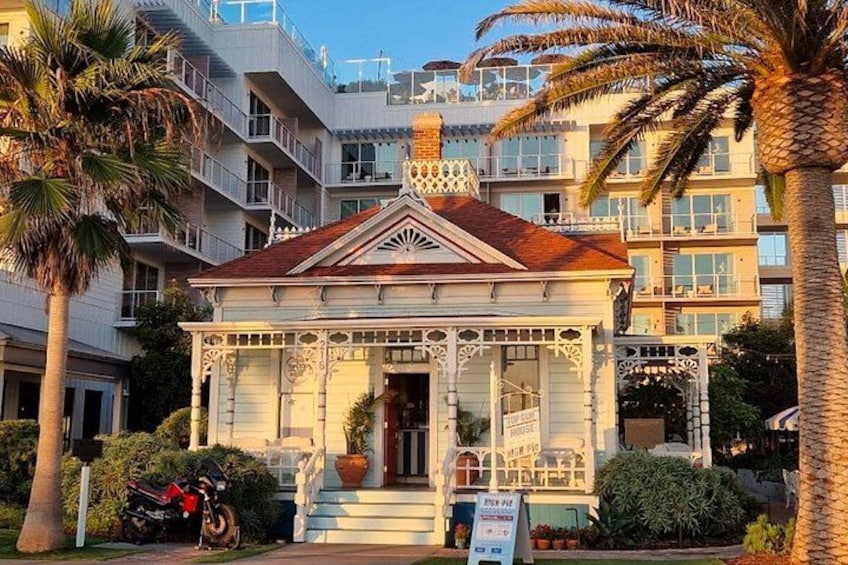 A small, ornate building with a red roof, surrounded by palm trees and other greenery. 1