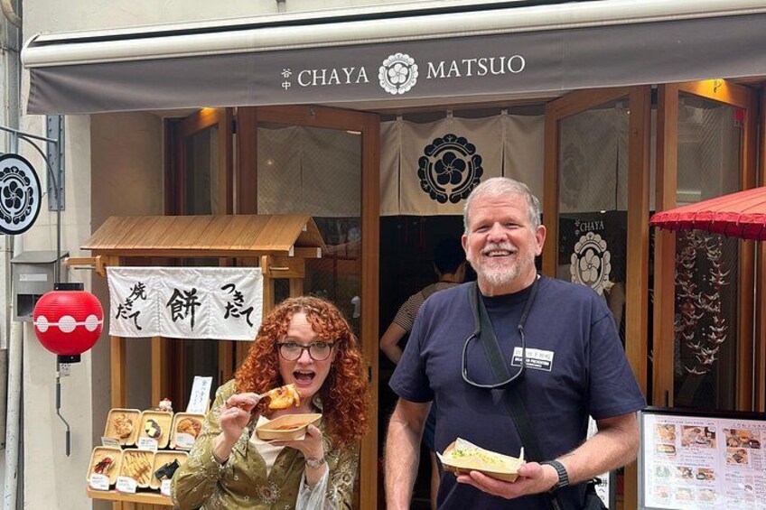 A street food stall with food items displayed and a person holding a food item. 4