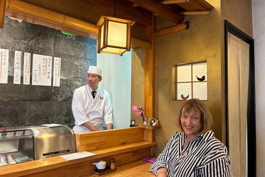A restaurant interior with a counter, a menu board, and a person in a white uniform. 2