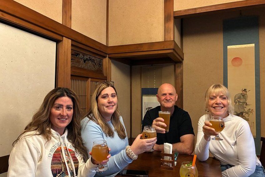 Four people sitting at a wooden table in a room with traditional decor. 3