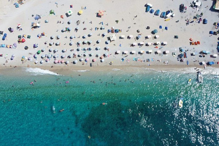 An aerial view of a beach with numerous umbrellas and people. 4