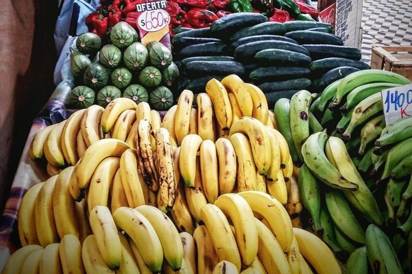 Un étal de fruits où l’on vend des bananes, des avocats, et où un panneau indique un prix de 1400. 4