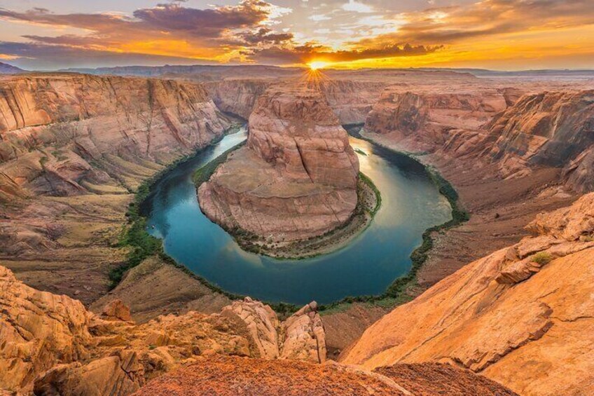 Une rivière serpentant à travers un canyon, avec un coucher de soleil en arrière-plan. 5