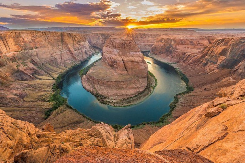 A river winding through a canyon with steep cliffs and a sunset in the background. 4