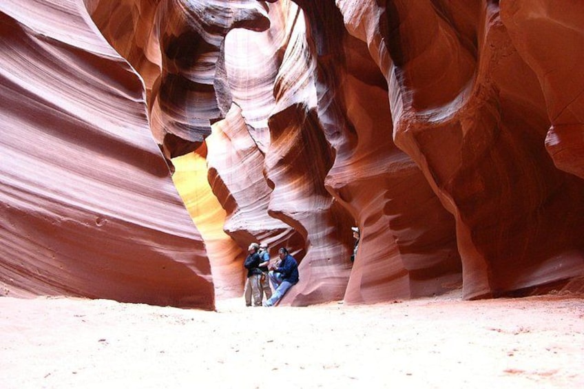 A canyon with layered rock formations and people hiking. 3