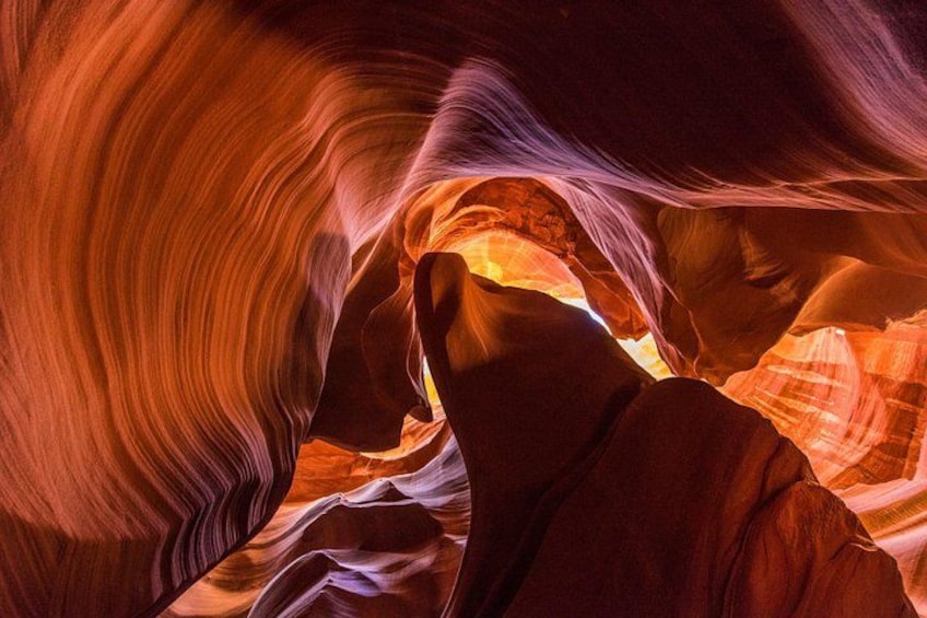 A canyon with smooth, flowing rock formations and a narrow passageway. 1