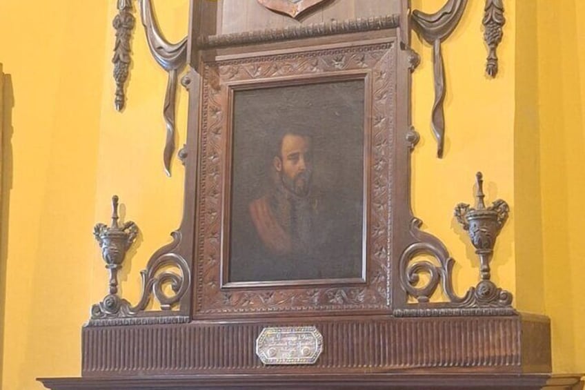 A framed portrait with ornate candle holders on either side. 3