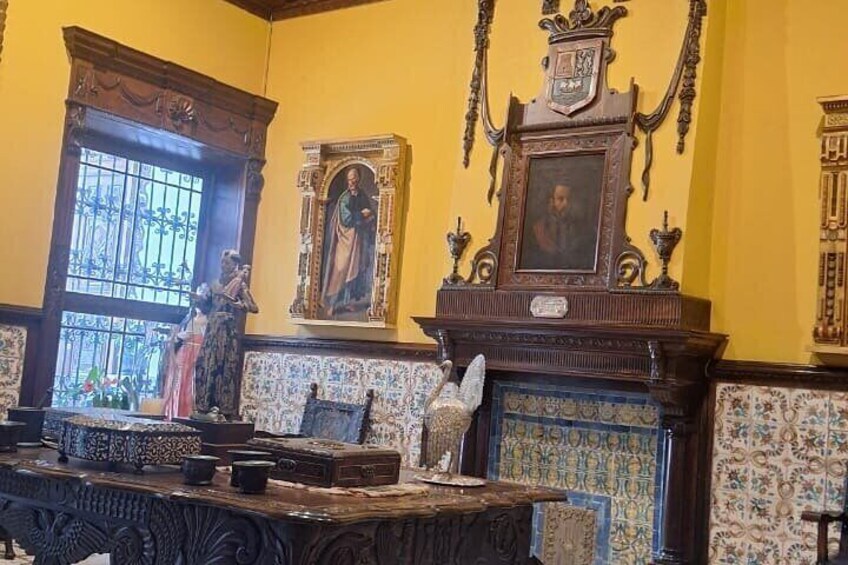 A room with ornate furniture, a fireplace, and a window with bars. 4