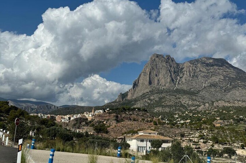 Un paisaje montañoso con un pueblo en primer plano y un pico destacado al fondo. 3