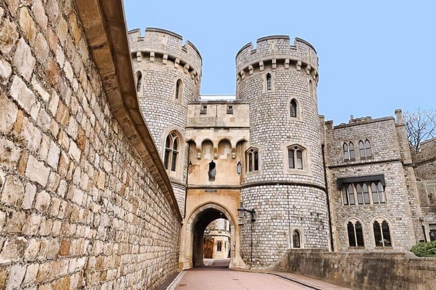 A medieval castle with stone walls, a central archway, and two round towers. 3