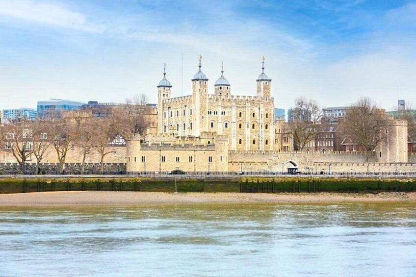 A historic building with multiple towers, a river in the foreground, and a cityscape in the background. 4