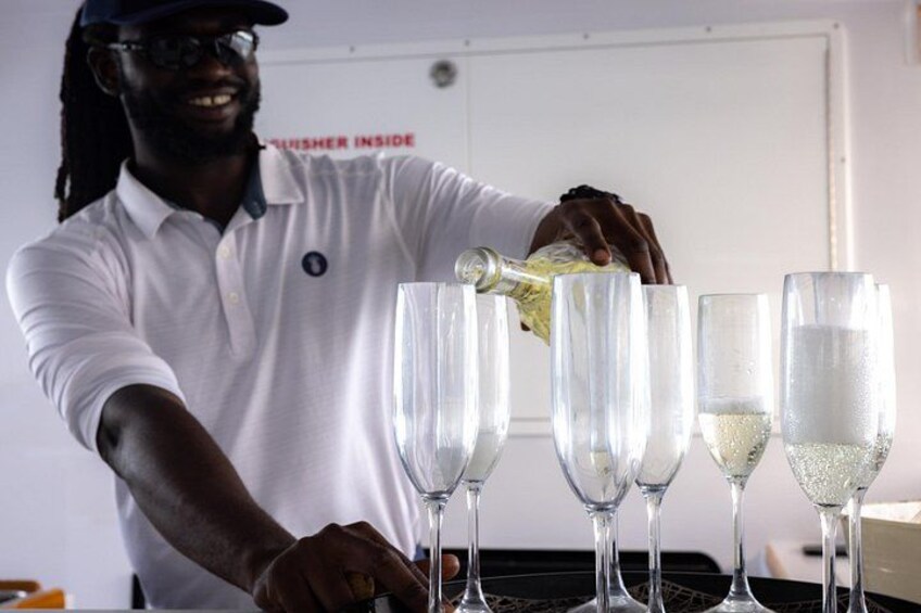 A person pouring a liquid into several glasses. 4