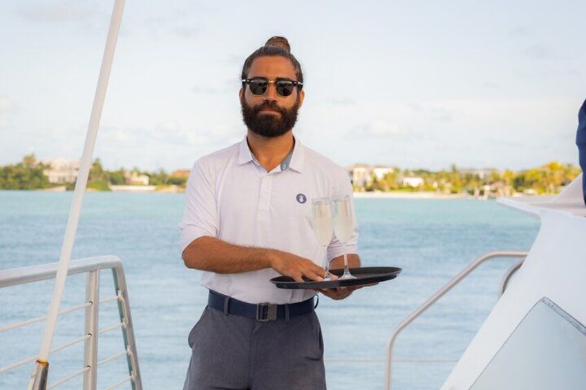 A person on a boat holding a tray with a glass. 2